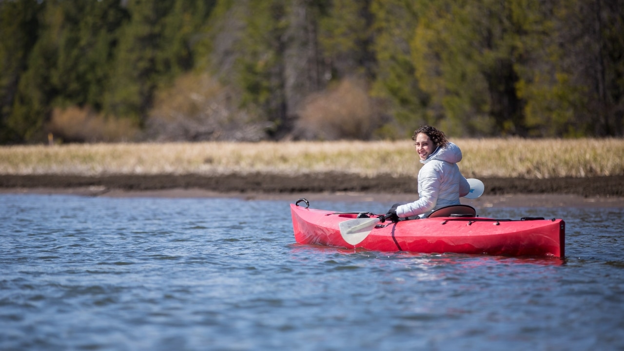 Woman paddling a red kayak