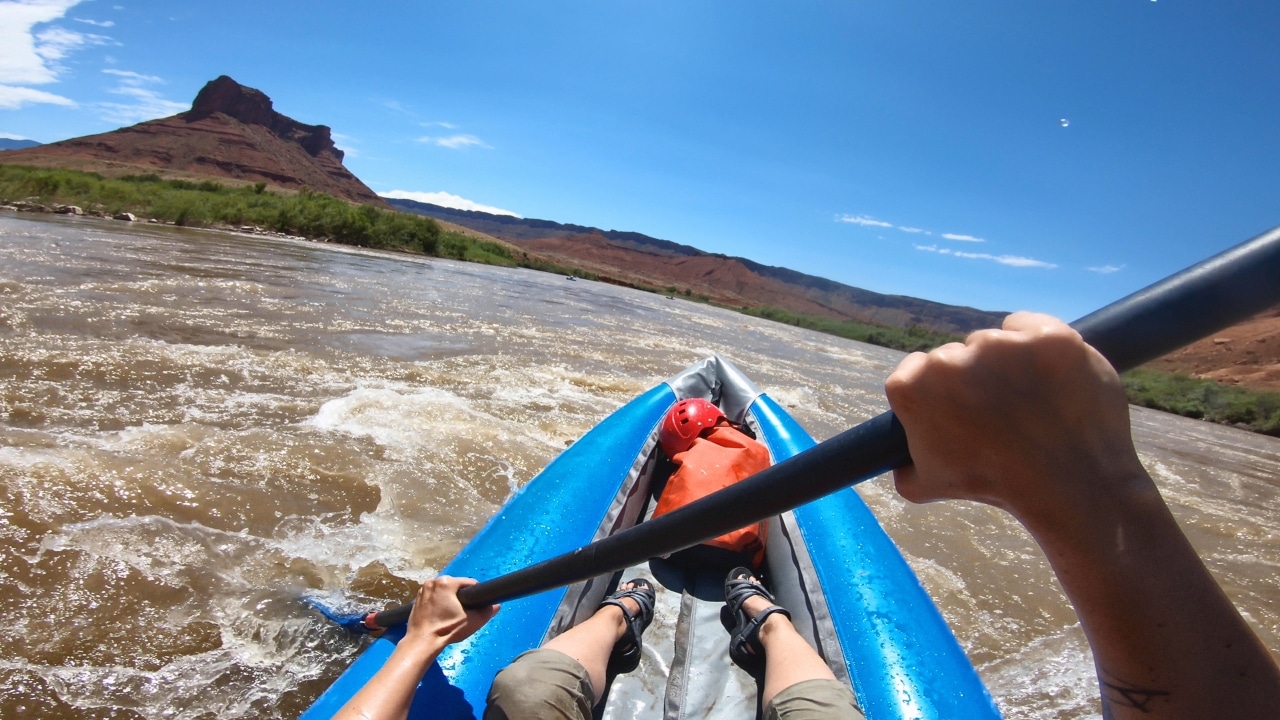 POV paddling an inflatable whitewater kayak